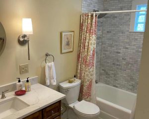 Bathtub with curtain and sink alongside